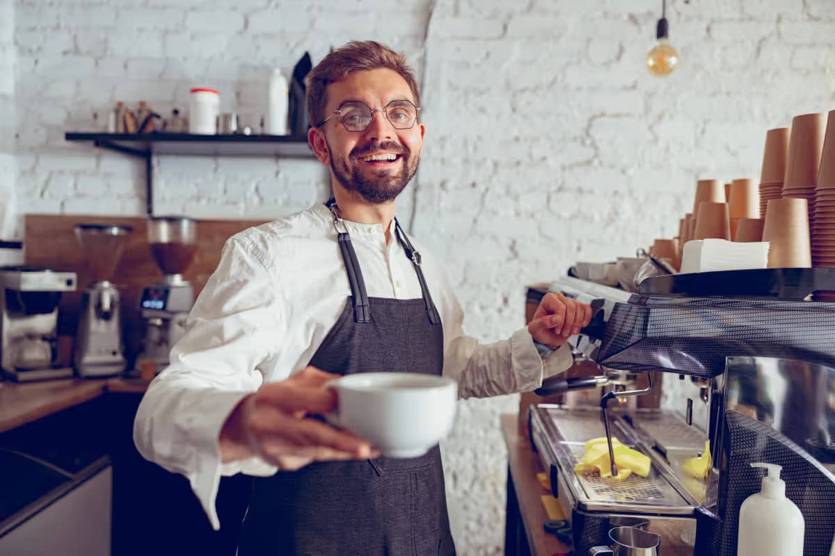 Barista übergibt fertige Bestellung am Counter
