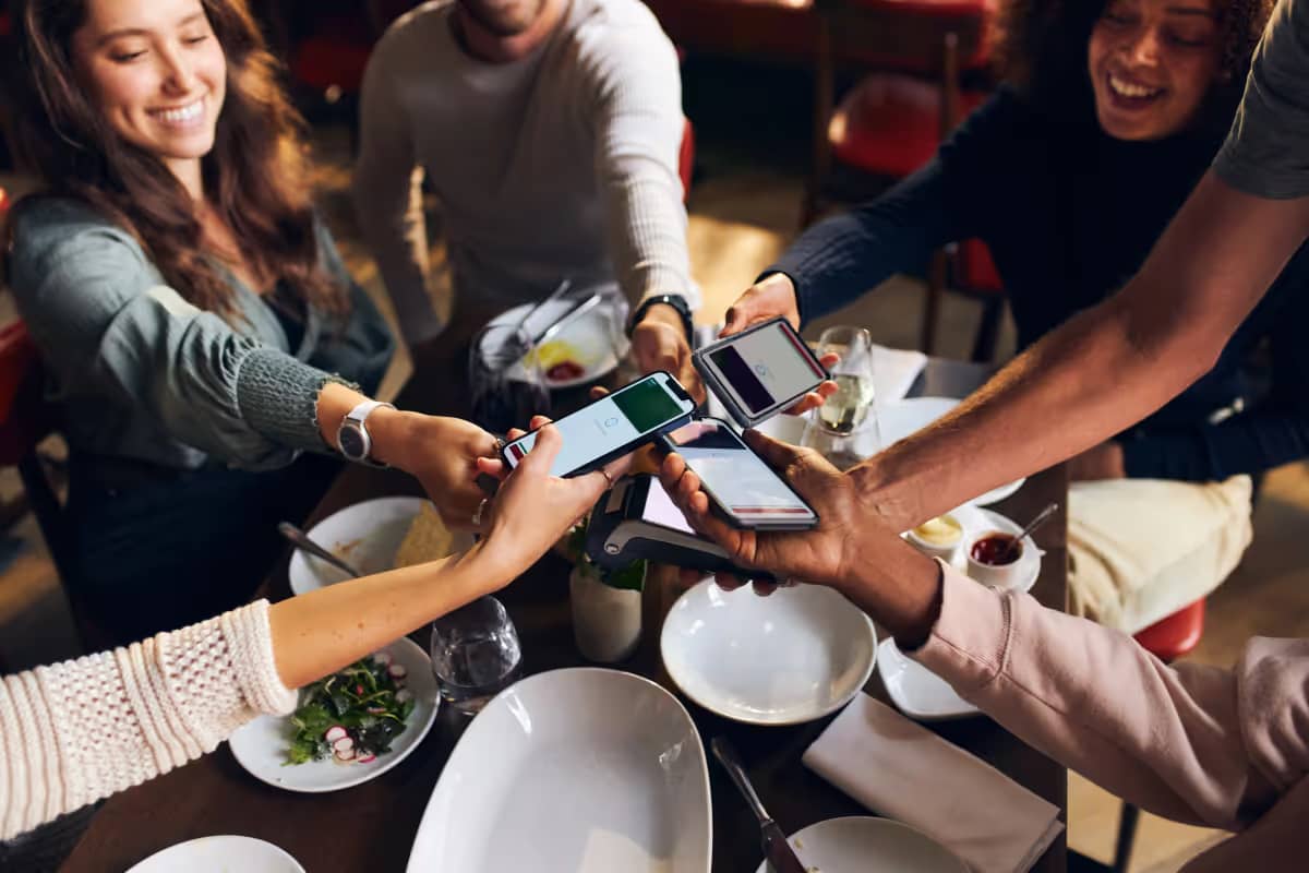 Freunde teilen die Rechnung im Restaurant